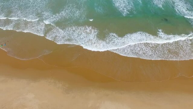 Ondas quebrando na praia tropical em dia ensolarado sem pessoas. V&iacute;deo a&eacute;reo de drone em Taipu de Fora, Bahia, Brasil.