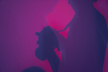 Background with a silhouette of a man with a camera, diffused light. Abstract gradient pink and...