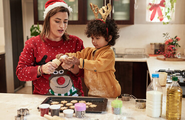 Mother, son and baking with christmas, snack and dough learning for cookies in kitchen together. Smile, food and celebration with woman, adopted child and boy in home to prepare sweet treat or love