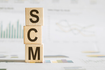 SCM blocks arranged to spell SCM on a table, representing Supply Chain Management concept.
