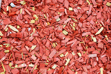 Finely chopped pieces of stained wood. Decorative element on a rock garden.