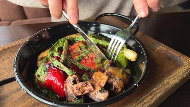eat grilled vegetables Close up side view of woman eating grilled chicken salad from wooden bowl.