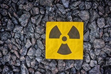 A radiation warning sign on a background of crushed granite. Close up.