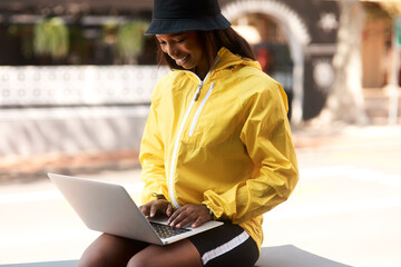 Internet, smile and black woman with laptop in city for freelance job, connectivity or email of...