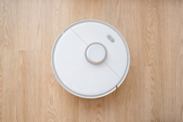 top view on smawrt vacuum cleaner on the floor. copy space banner, smart house concept