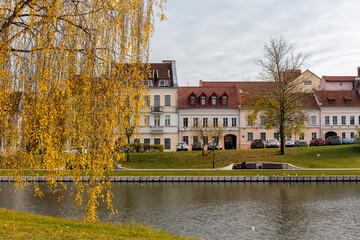 Obraz premium The Trinity Suburb in Minsk, Belarus, old colorful traditional buildings in the oldest district in Upper City Minsk by Svislach River in autumn with orange autumn leaves.