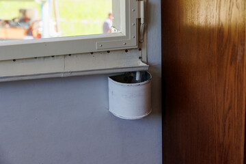 A container for collecting condensation on a historic window in an old farmhouse