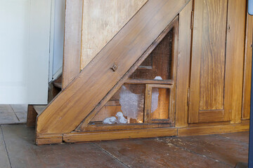 A chick coop under a staircase in the parlour of an old farmhouse