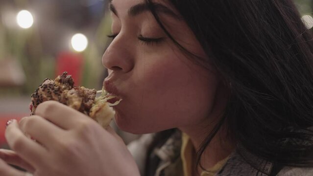 Women enjoying a bite of their burgers at the restaurant