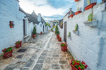 Trulli of Alberobello, Puglia, Italy. town of Alberobello with trulli houses among green plants and...