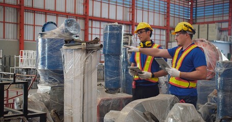 Fototapeta premium Workers partners in uniform safety and hardhat holding tablet Talking on a Meeting in Metal Construction Manufacture industry factory, Engineers man industrial discussing project work. Team work