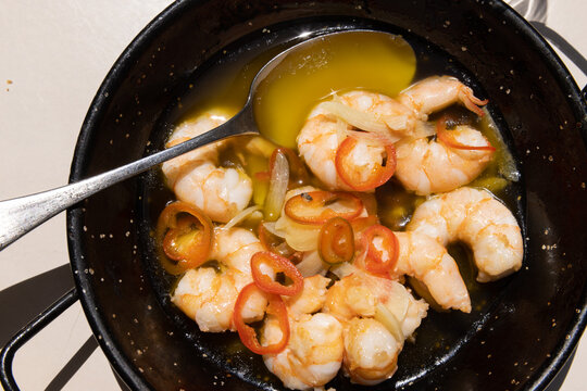 Garlic shrimp with butter and topped with chiles served in a cast iron pan in Portugal. 