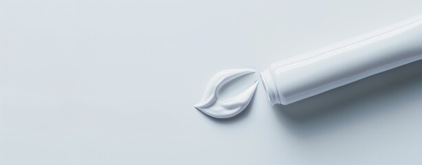 Minimalistic image showcasing a white tube with cream squeezed out against a clean, pale blue background, creating a sense of hygiene, healthcare, and simplicity