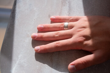 man wearing silver wedding ring on his finger in close-up