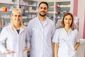 Fototapeta premium Portrait of three smiling pharmacists that are standing in the pharmacy.