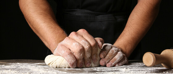 Man kneading dough in kitchen, closeup