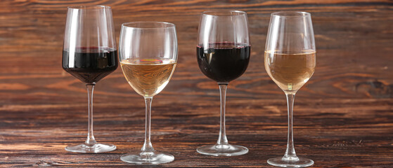 Glasses of different exquisite wine on wooden background