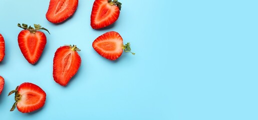 Fresh cut strawberries on light blue background with space for text, top view