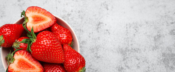 Bowl of fresh strawberries on grey grunge background