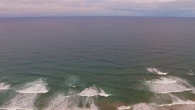 V&iacute;deo a&eacute;reo de ondas quebrando no mar de Taipu de fora, litoral da Bahia, Brasil, durante o entardecer.