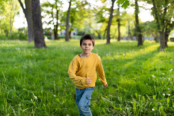 Portrait of little adorable smiling boy on spring sunny day in park