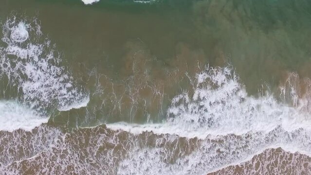 Ondas vistas de cima quebrando no mar. Filme a&eacute;reo de drone em tr&ecirc;s alturas distintas registrando praia do litoral do nordeste brasileiro.