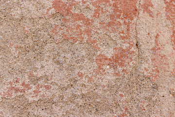 Old plaster coming off and showing concrete wall. Close-up of a crumbling plaster wall revealing layers and texture