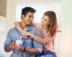 Couple, hug and love in house with coffee for relationship, date and time together in living room. Man, woman and support with happiness, tea and smile in home for connection, care and commitment