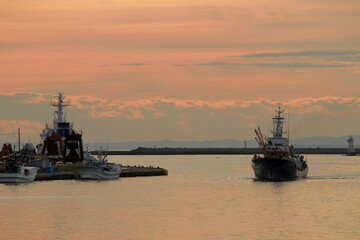 Fototapeta premium Beautiful scenery in Japan Kushiro Port at dusk and a small fishing boat returning to port