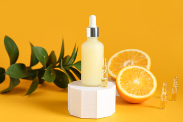 Plaster podium with bottle and ampule of vitamin C on orange background