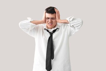 Tired young businessman on light background