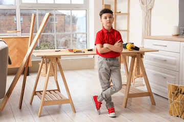 Portrait of cute little builder in room