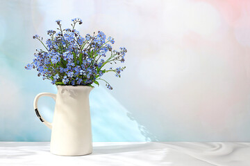 Beautiful spring forget-me-not flowers in a vase on a light background, flyer. Abstract flower arrangement, still life with space for text, floral holiday card, summer greeting concept,