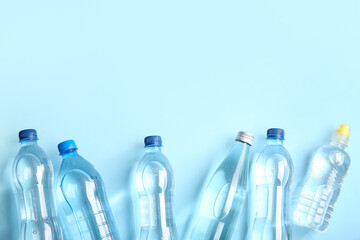 Plastic bottles of clean water on blue background