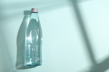 Glass bottle of clean water on color background