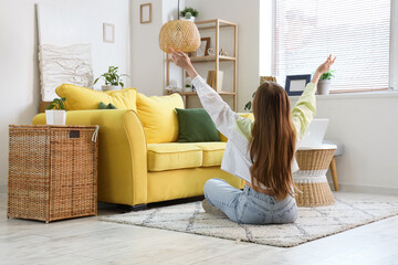 Young woman sitting on floor in stylish living room