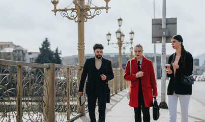 Three stylish friends walking on a city bridge with clear skies above, enjoying urban life and...