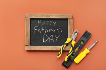 Tools and chalkboard with text HAPPY FATHER'S DAY on orange background