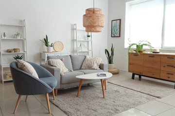 Interior of modern living room with grey sofa, coffee table and armchair