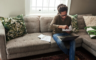 Documents, finance and laptop with black man on sofa in living room of home for bank or payment....