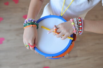 Criança sorrindo feliz  menina pré adolescente fazendo musica com tambor colorido