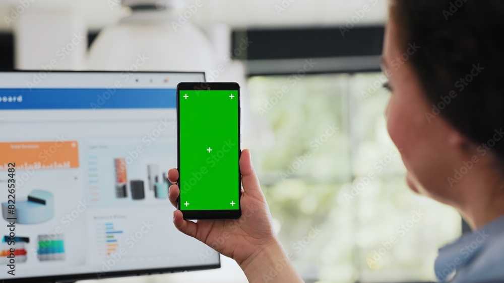 Poster worker checking greenscreen display on smartphone, holding device with copyspace blank software in c