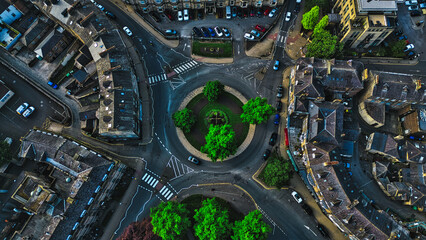Aerial view of a roundabout with green trees and surrounding buildings in Harrogate, North Yorkshire © iSky Media
