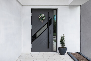 Designer entrance door to a country house. Modern design. Luxurious exterior. Facade of a modern building with modern doors.