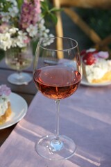 Glass of wine on table served for romantic date in garden
