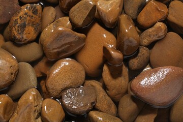 Beautiful pebbles in water as background, top view