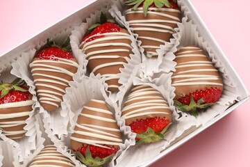Box with delicious chocolate covered strawberries on pink background, top view