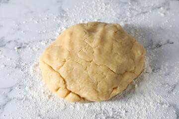 Making shortcrust pastry. Raw dough and flour on white marble table