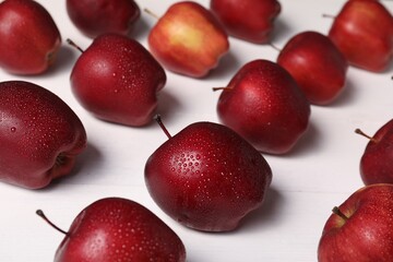 Fresh red apples with water drops on white wooden table, closeup