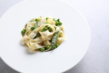 Delicious pasta with green peas on grey table